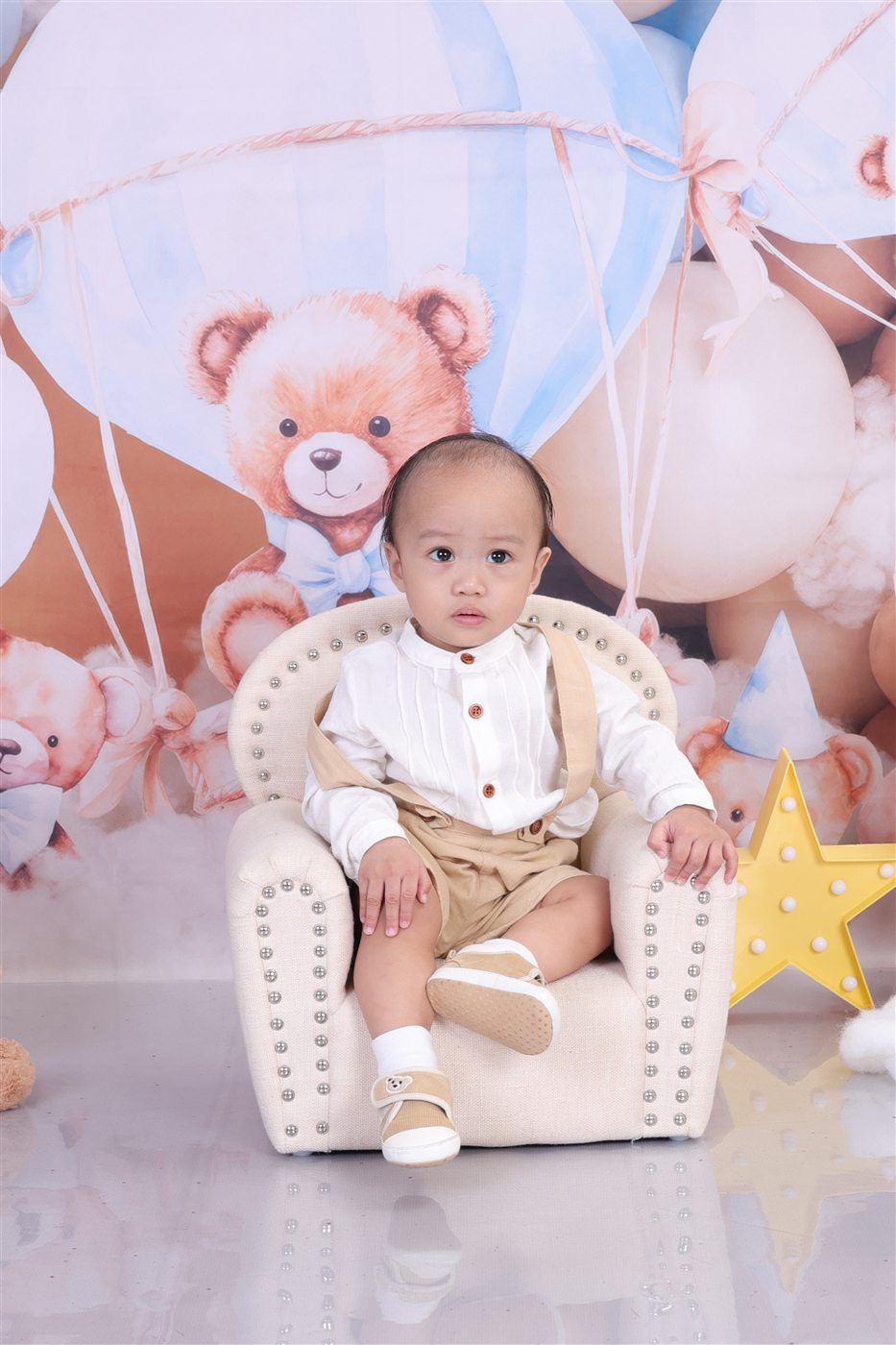Jaden Matthew seated calmly in a cream chair for his dedication celebration
