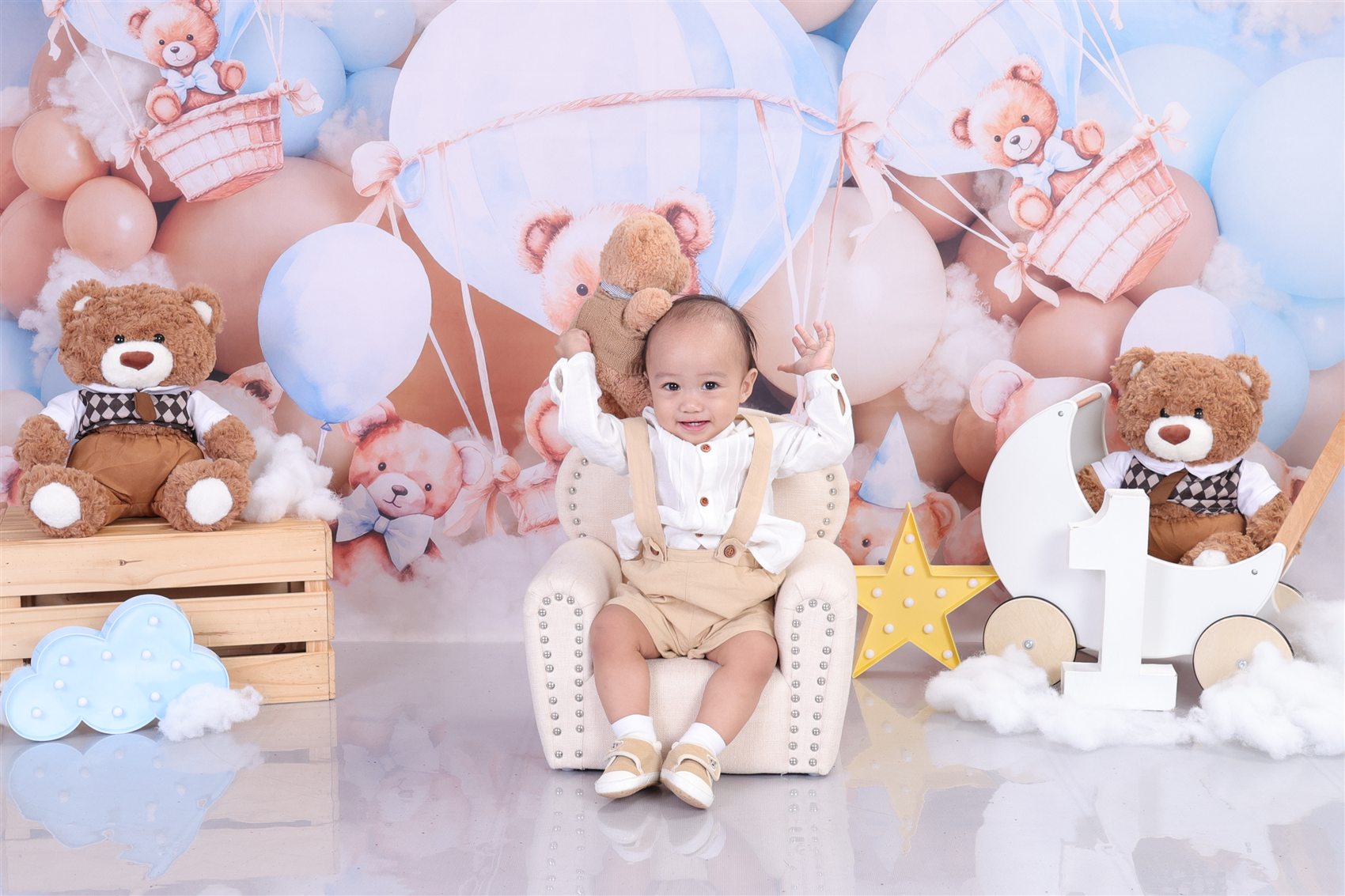 Jaden Matthew smiling with a teddy bear during his first birthday photoshoot